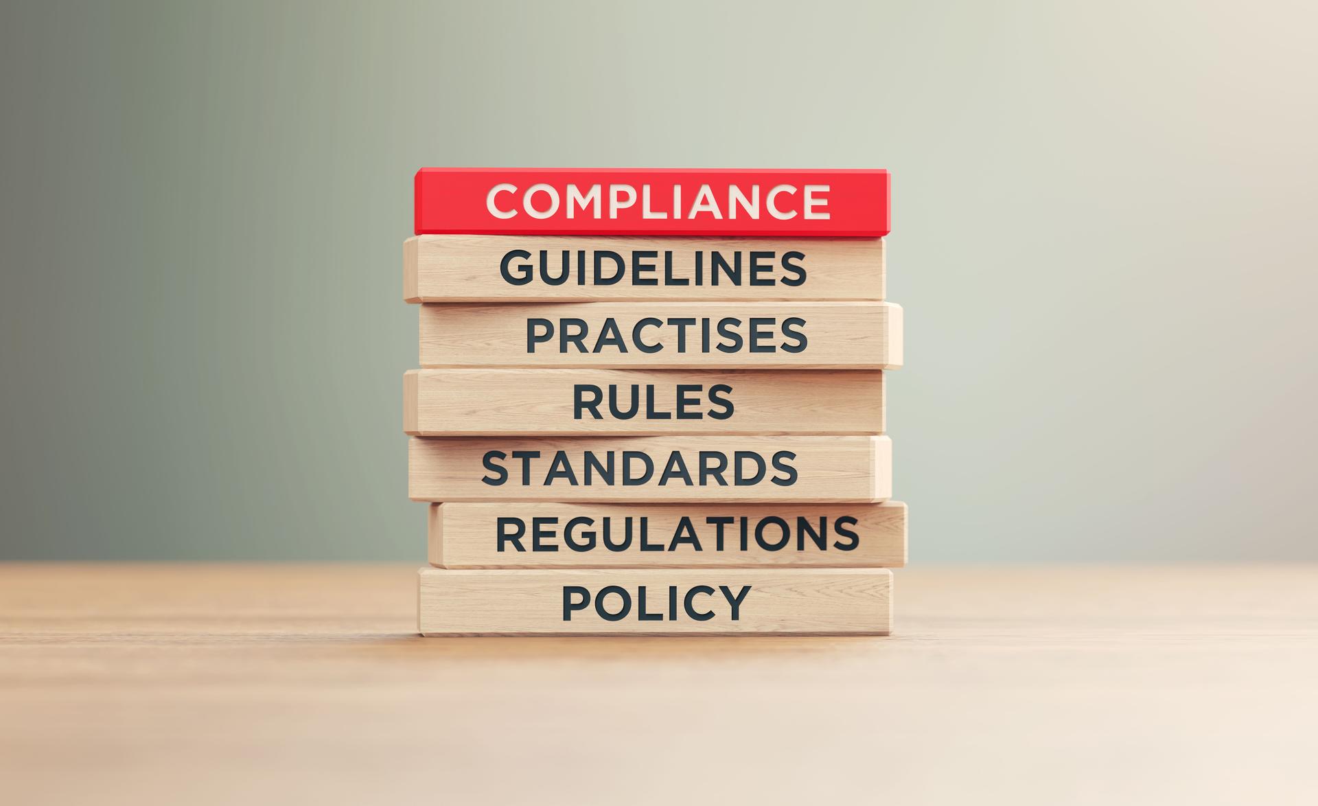 Compliance Related Words Written Wood Blocks Sitting on Wood Surface in Front a Defocused Background